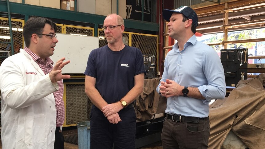 Matt Canavan speaks with two men at a workshop