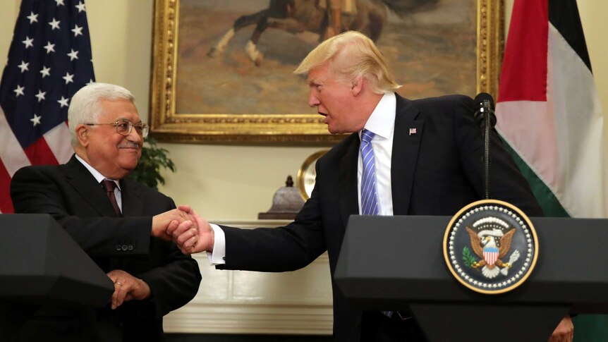 US President Donald Trump shakes hands with Palestinian President Mahmoud Abbas.