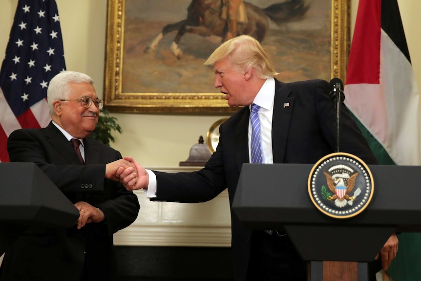 US President Donald Trump shakes hands with Palestinian President Mahmoud Abbas.