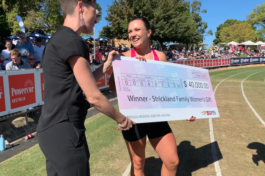 Hayley Orman smiles as she accepts a huge $40,000 cheque for placing first in the Stawell Gift Strickland Family Women's Gift.