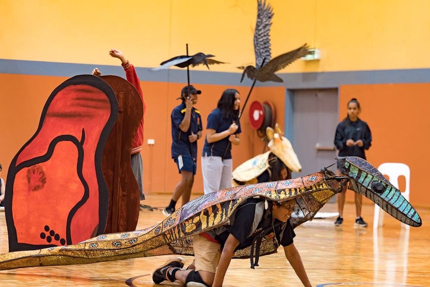 Performers of How Languages Came to Be rehearse in a gymnasium.