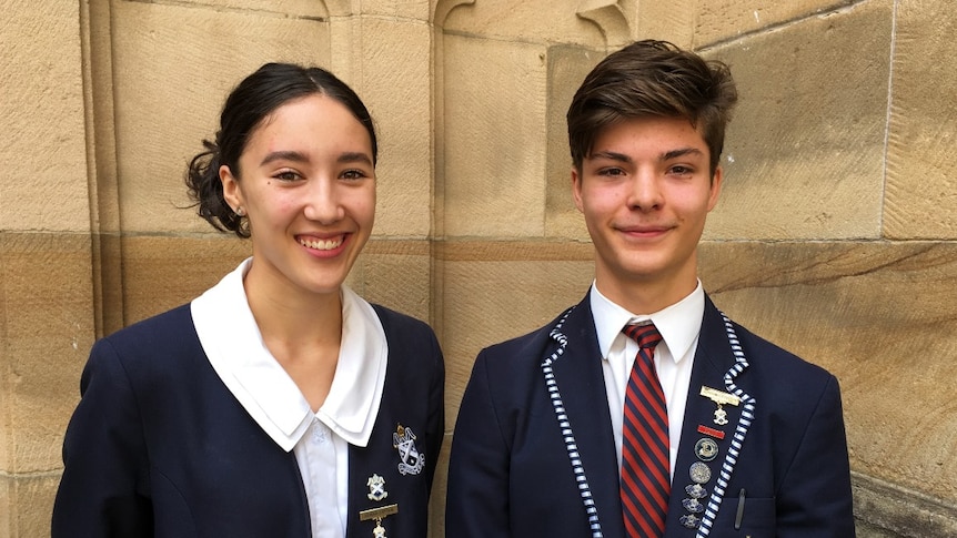 A young woman and a young man side by side in school uniform.