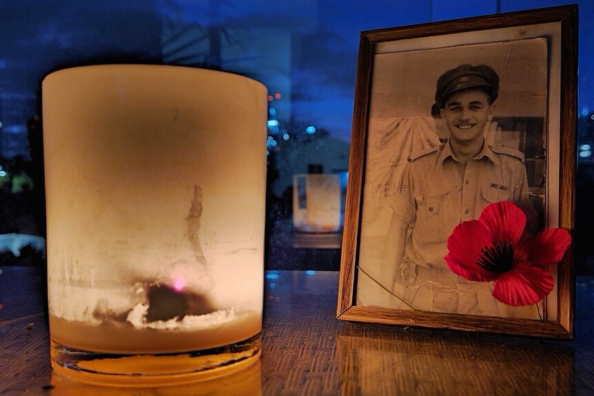 a picture of a man in uniform next to a candle on a sill