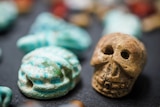 A small brown skull figure next to a small blue figure.