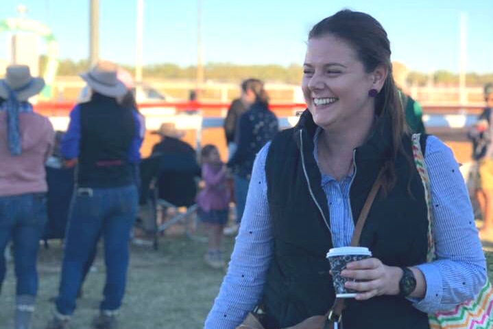 Young smiling woman holding takeaway coffee cup