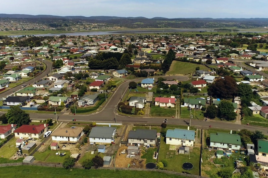 An aerial view over the rooftops of houses.