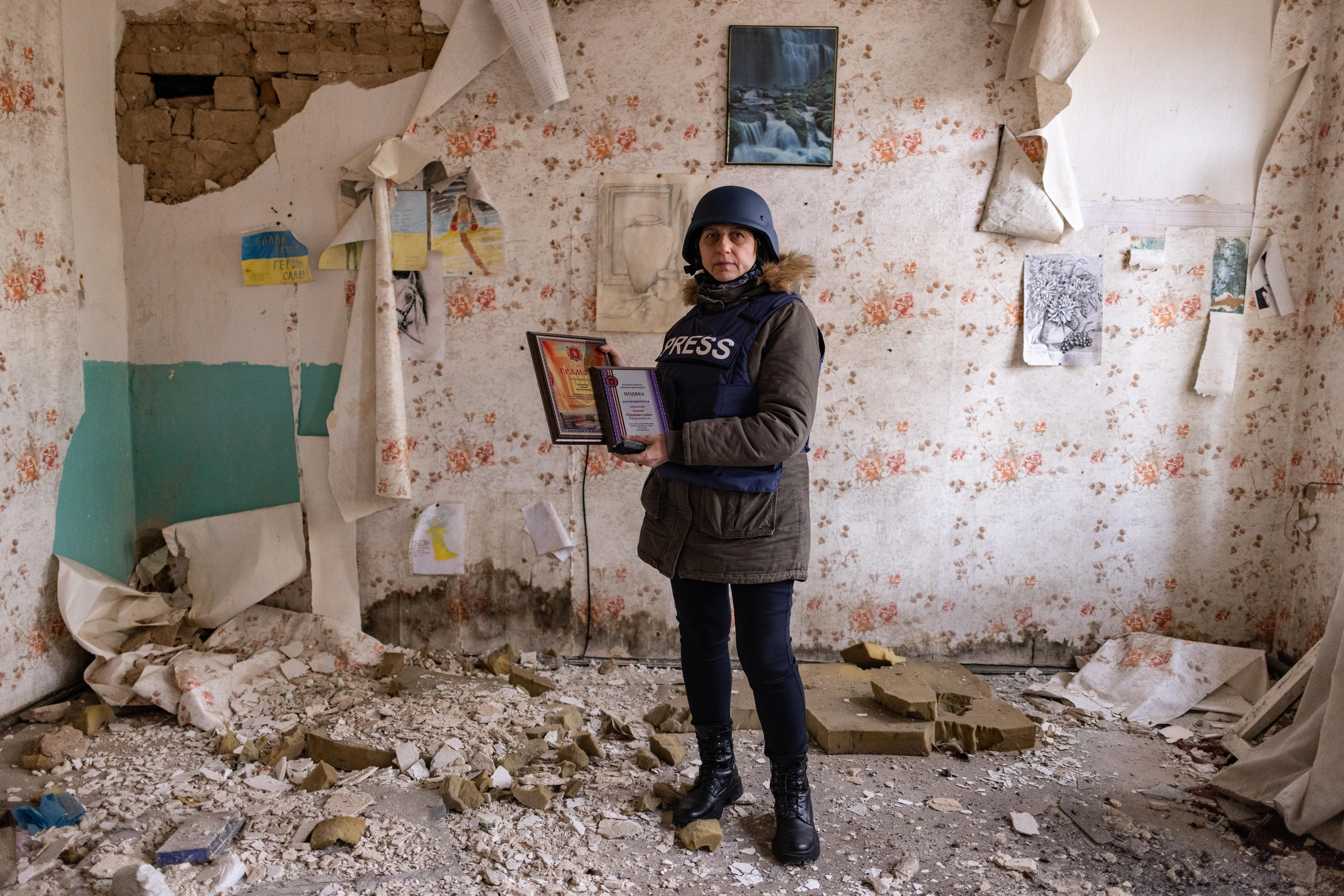 A woman standing in a bombed out office.