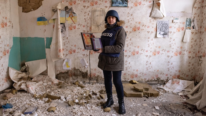 A woman standing in a bombed out office.