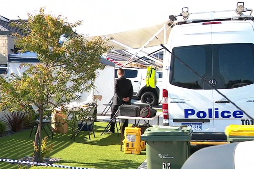 A police van and tables and chairs set up outside a suburban house.