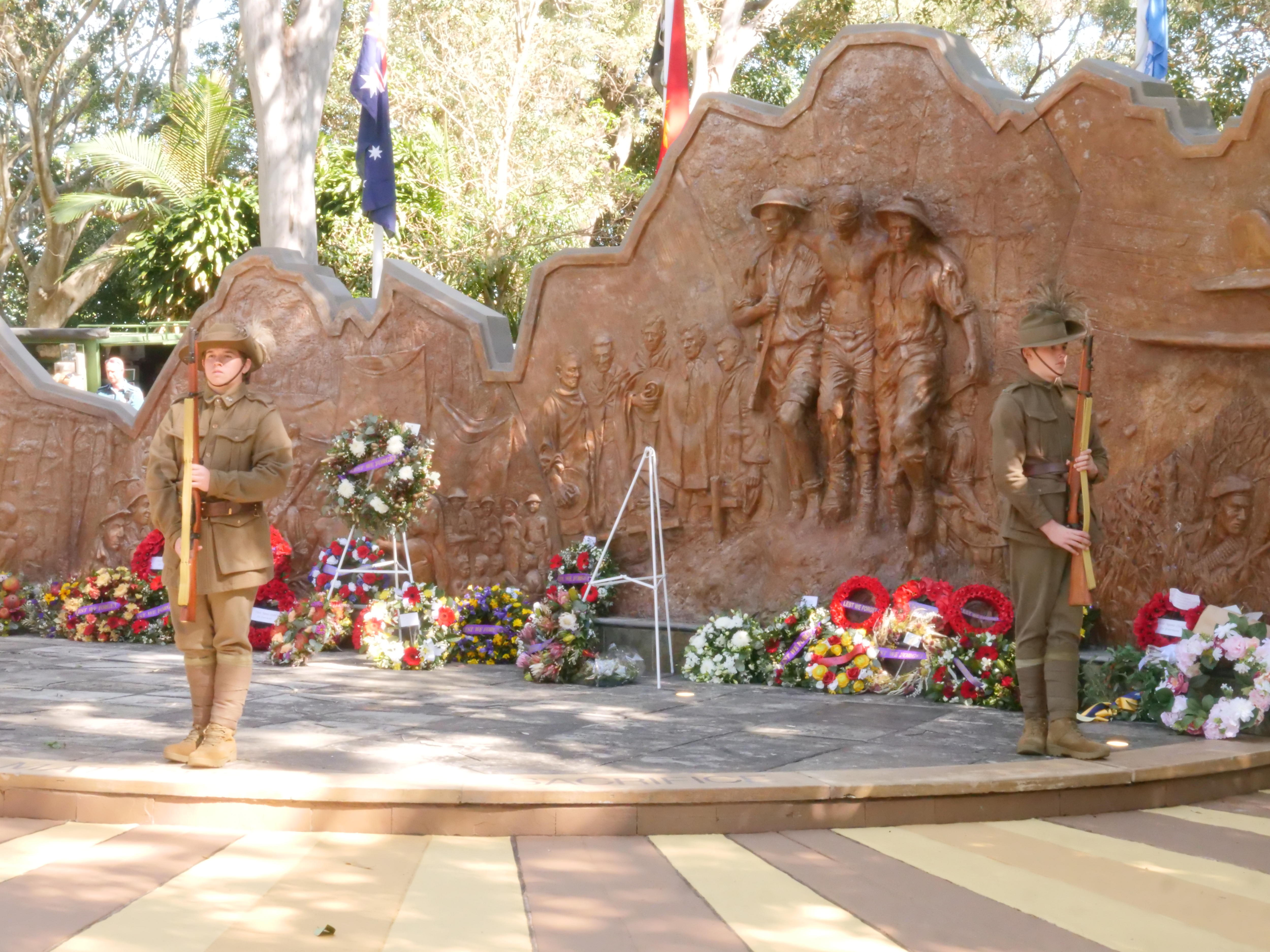 a large stone sculpture with wreaths in front of it.