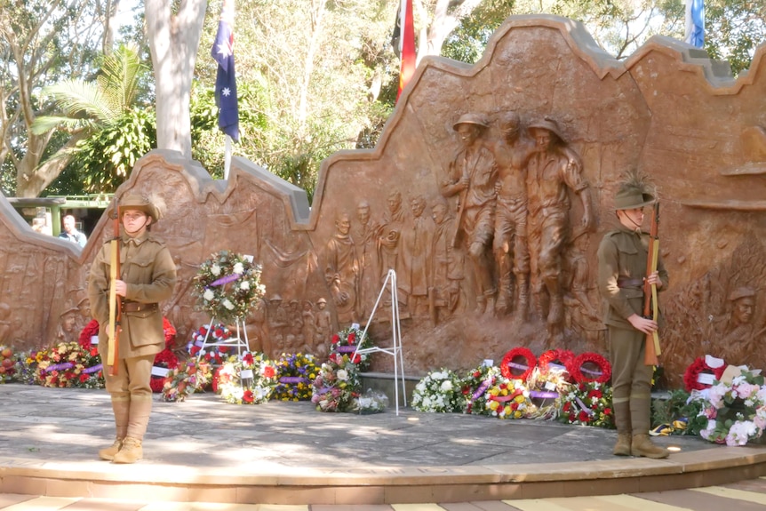 a large stone sculpture with wreaths in front of it.