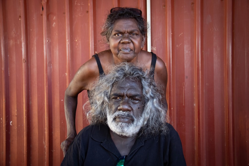 A portrait of a woman standing behind a man.