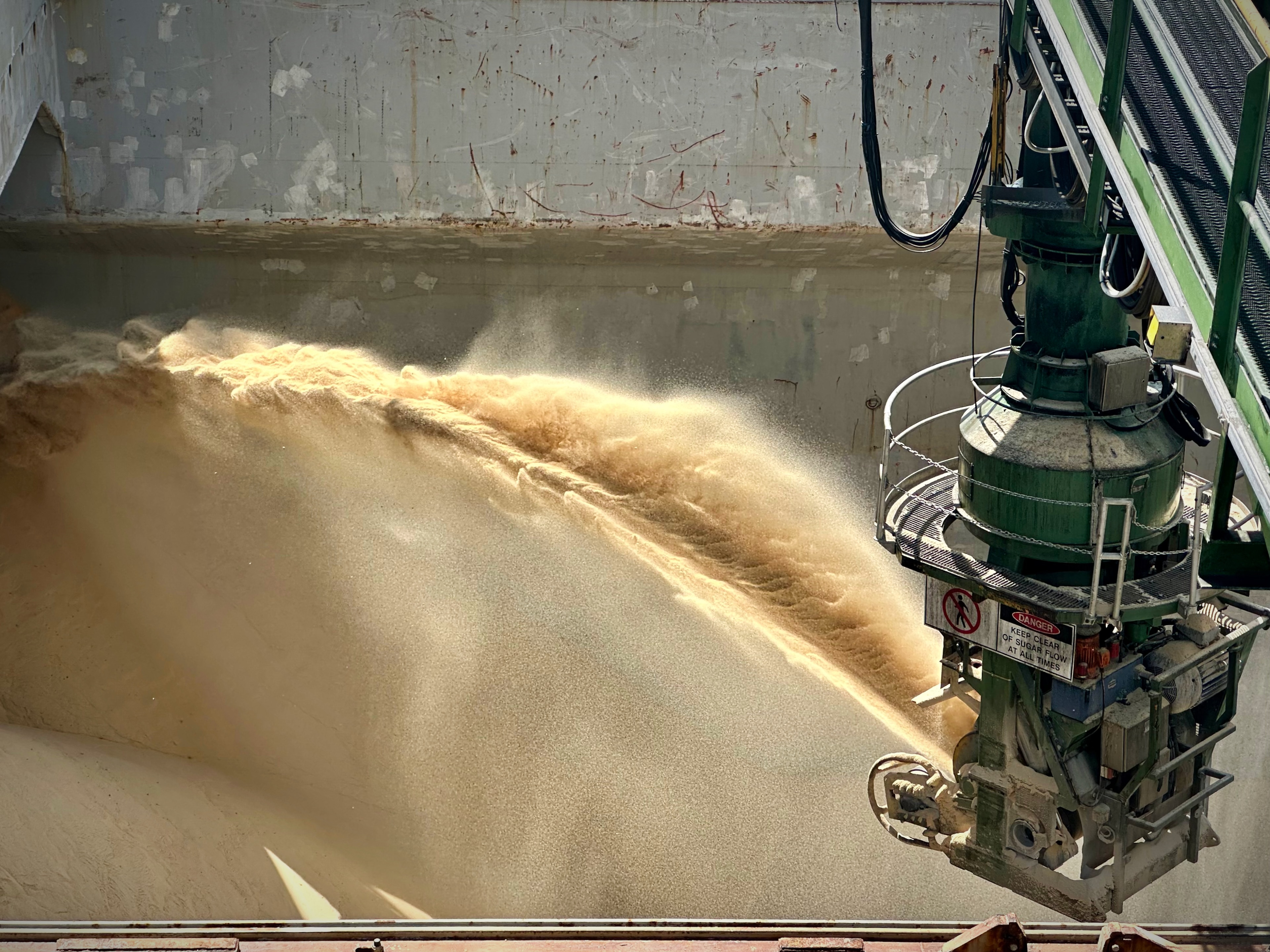 Large volumes of raw sugar being unloaded onto a ship