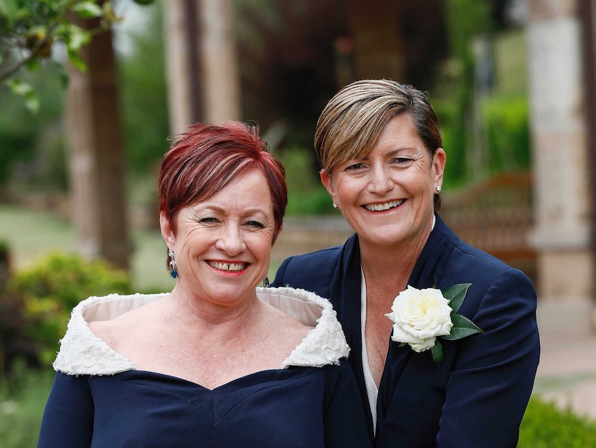 Virginia Flitcroft and Christine Forster stand together at their wedding ceremony.