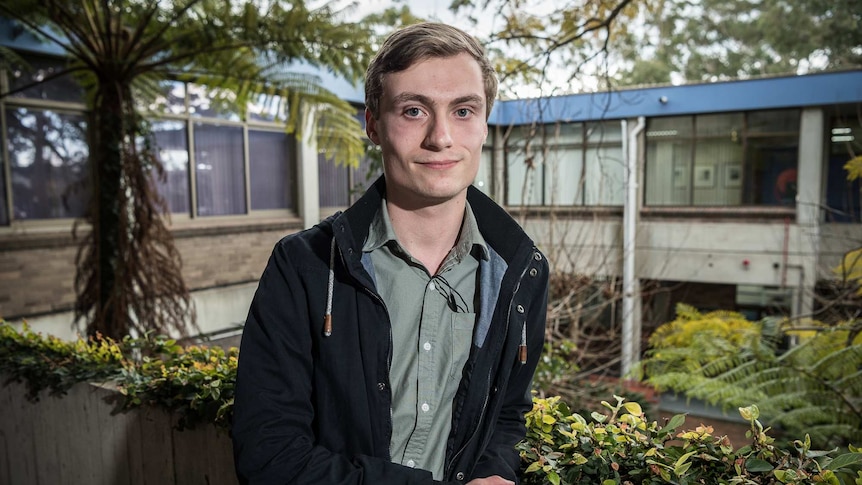 Liam Mills stands on a TAFE balcony and looks at the camera.