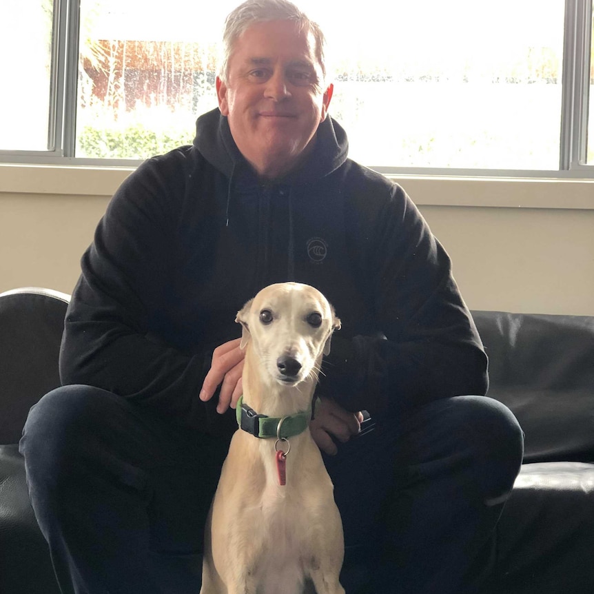 Pete Murphy sits with his dog, Colin. Colin is a whippet.