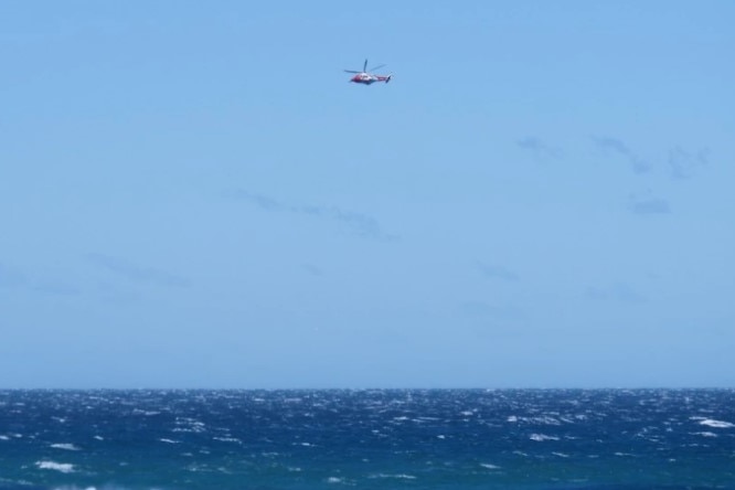 A search helicopter passes over choppy seas during the search for the missing helicopter