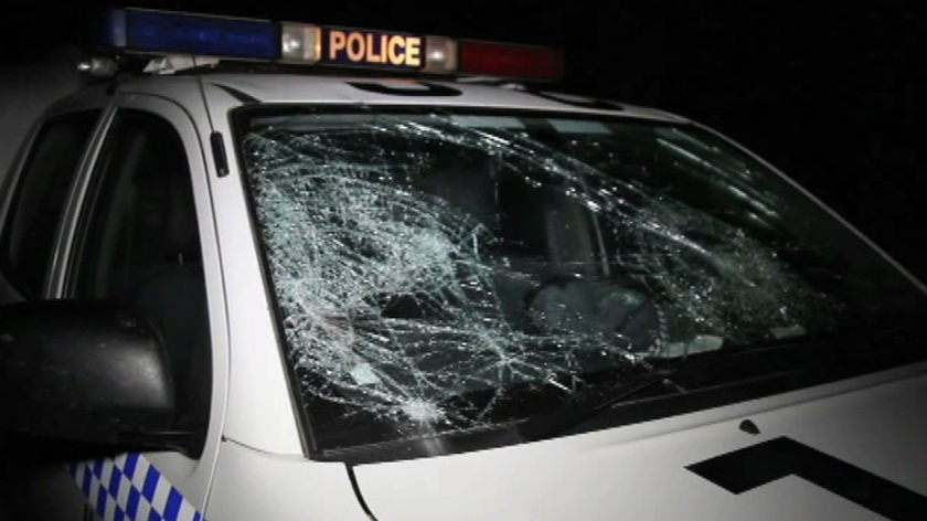 TV still of police car damaged by partygoers at Yamba