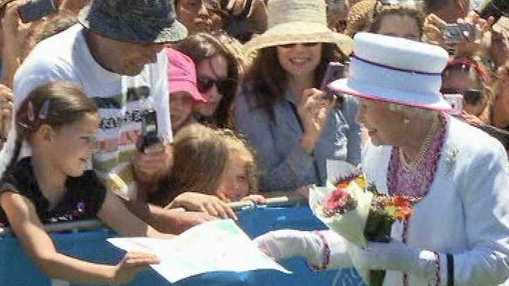 A young girl gives a picture to the Queen