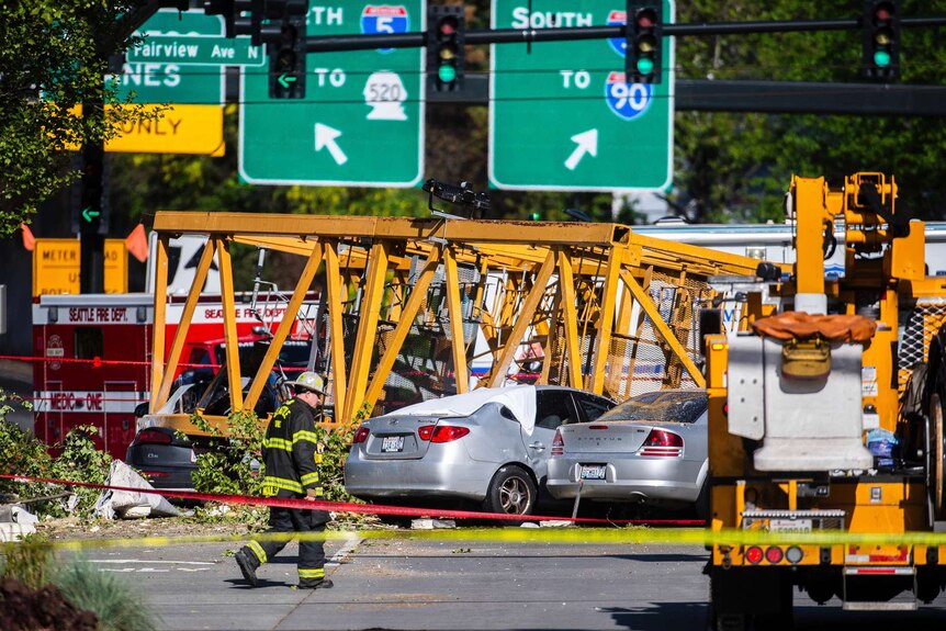 Emergency services workers surround cars crushed by a crane in Seattle.