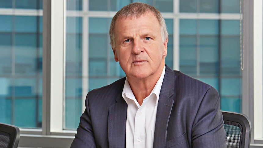 Garry Weaven sits at a desk