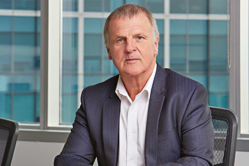 Garry Weaven sits at a desk