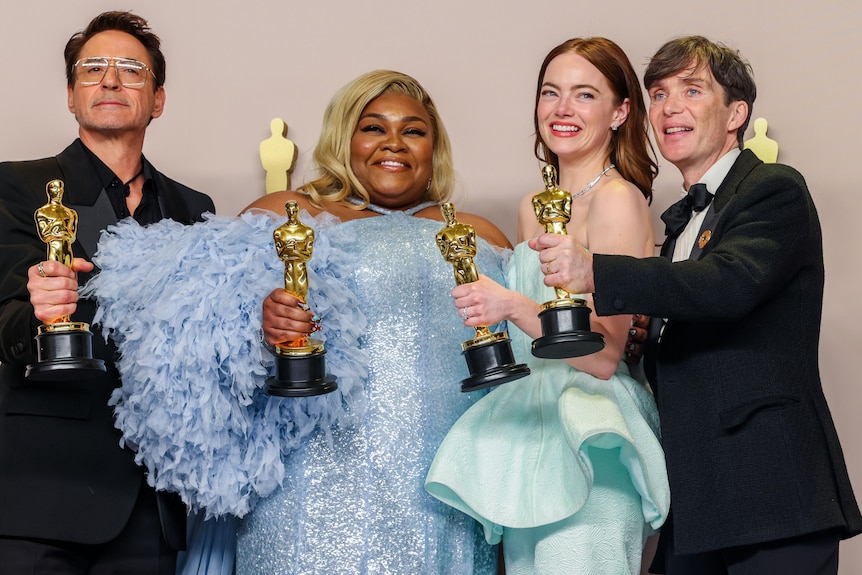 The four actors and actresses smile and pose for a photo, each holding up their gold Oscars statue.