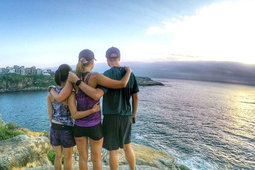 Three runners overlooking looking out over the ocean