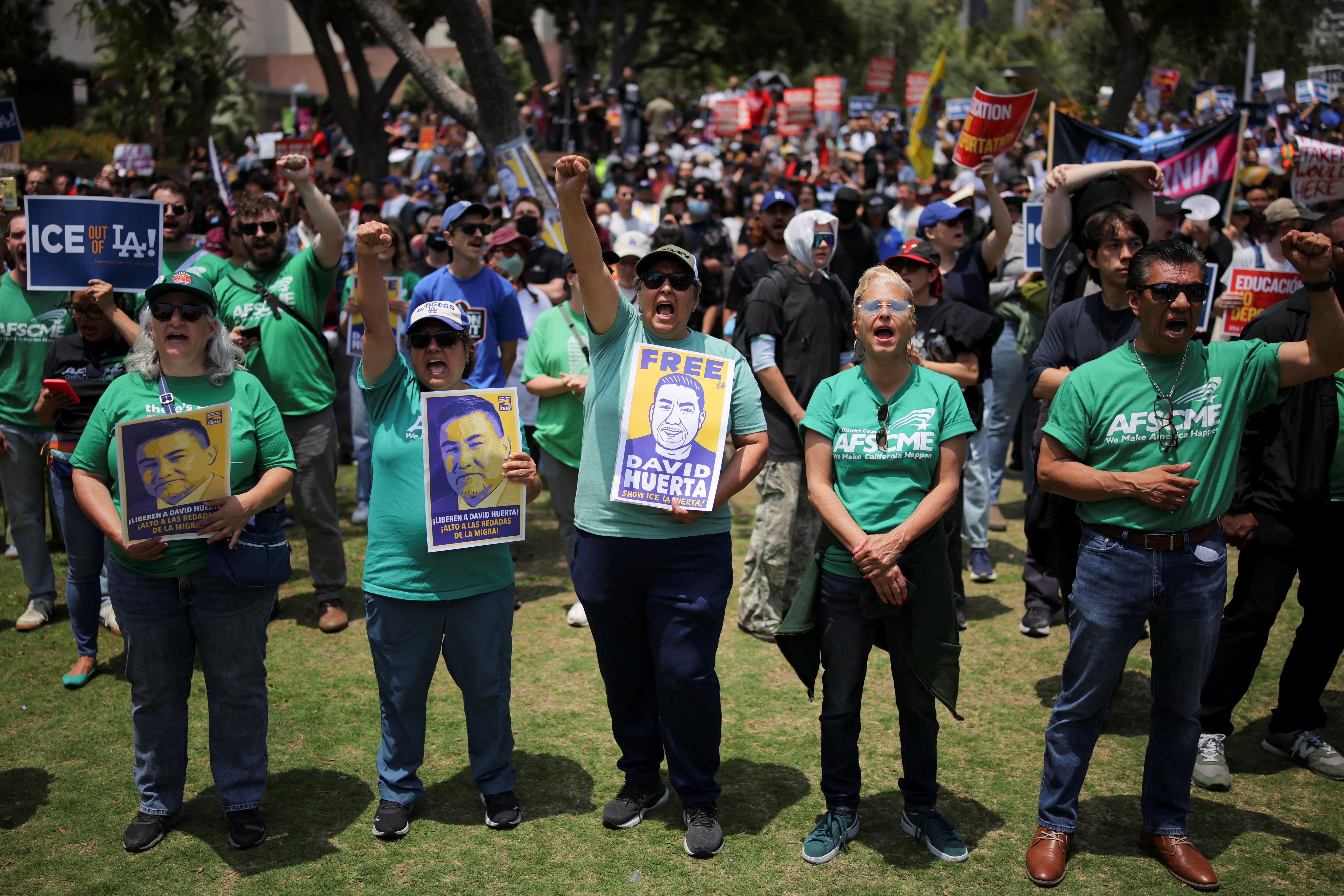 women holding free david huerta placards with fists in the air