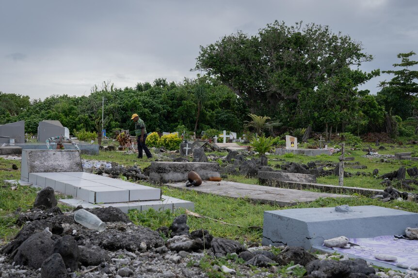 A photo of Kalorip Sope walking through the cemetery.