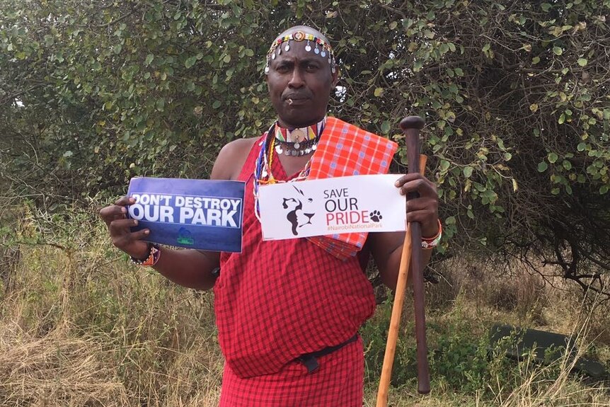 Conservationist holds up signs supporting the protection of Nairobi National Park