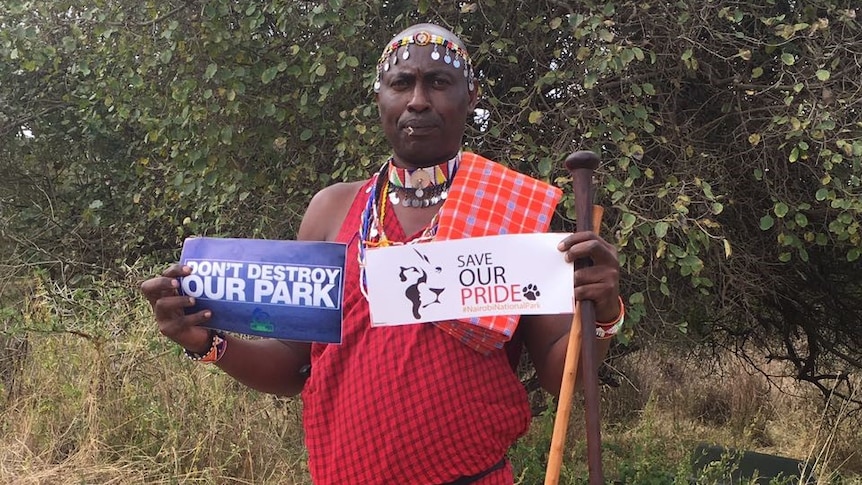 Conservationist holds up signs supporting the protection of Nairobi National Park