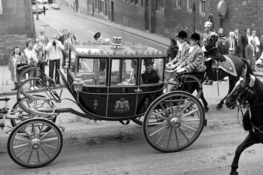 A black and white photo of a horse-drawn carriage