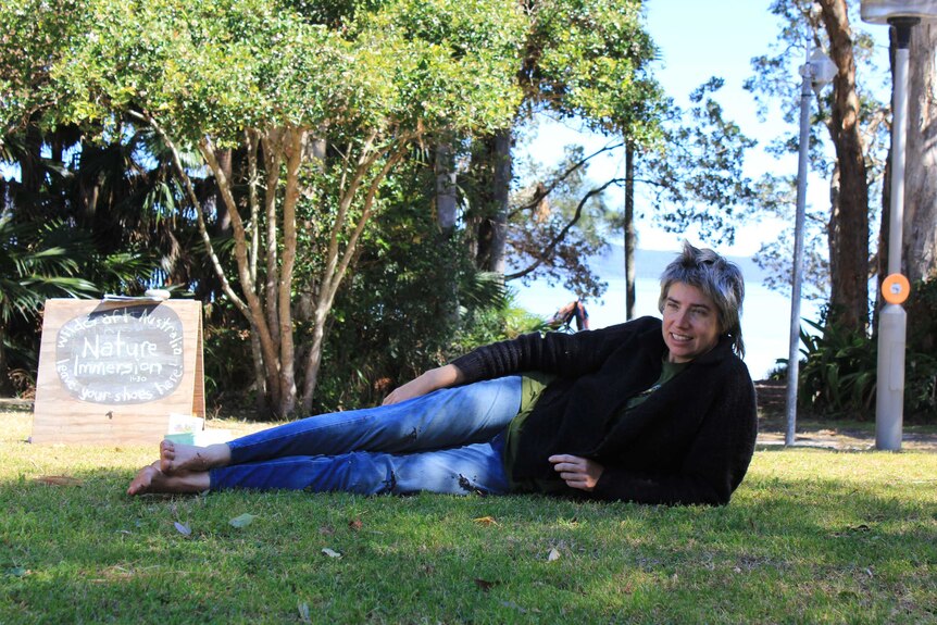 Wildcraft Australia Co-owner Jo new laying barefoot on the grass waiting to begin class at the Women's Adventure Summit.