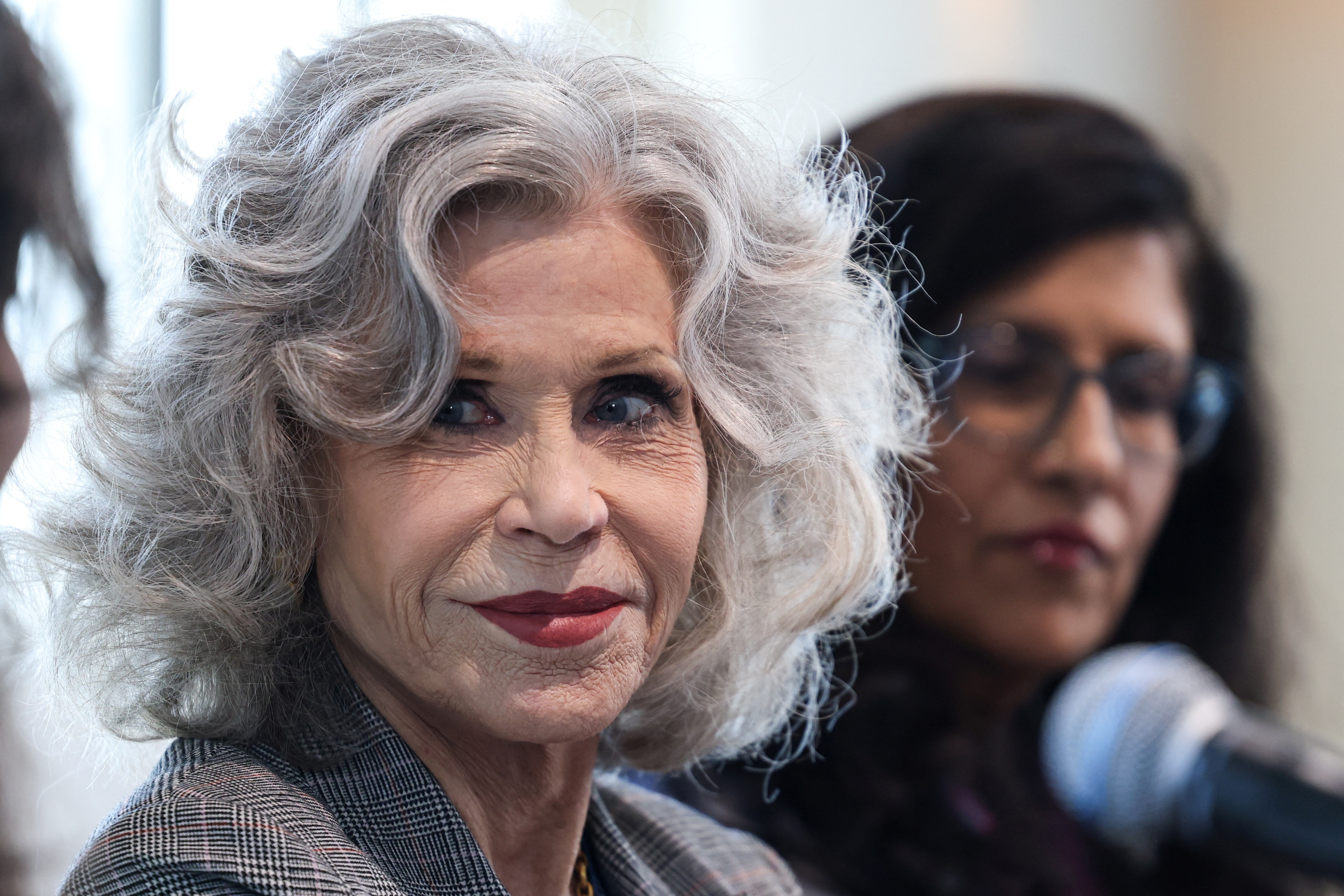 Woman with grey curly hair looking to the left 