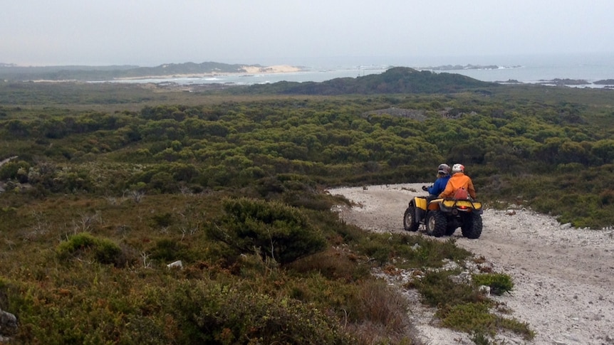 Two riders on a quad bike make their way on a track on Tasmania's west coast.