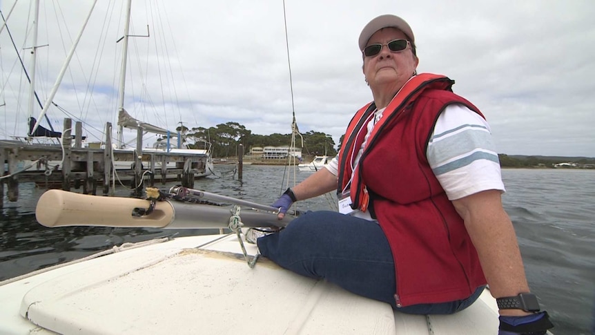 A woman sitting on a sailing boat on the ocean.