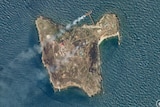A satellite image shows smoke rising from Snake Island