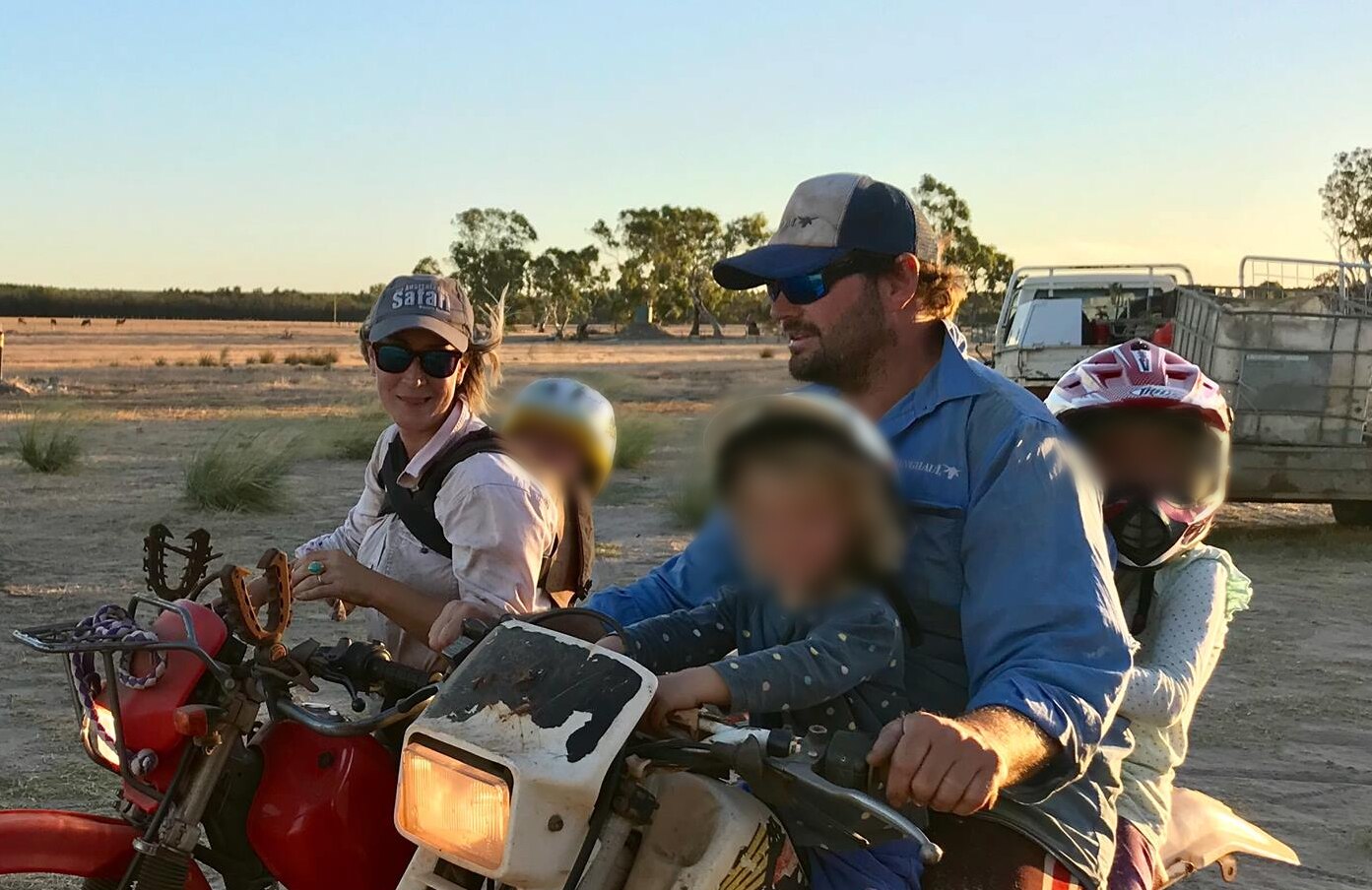 A woman and man on motorbikes, with blurred faces of their children riding with them.
