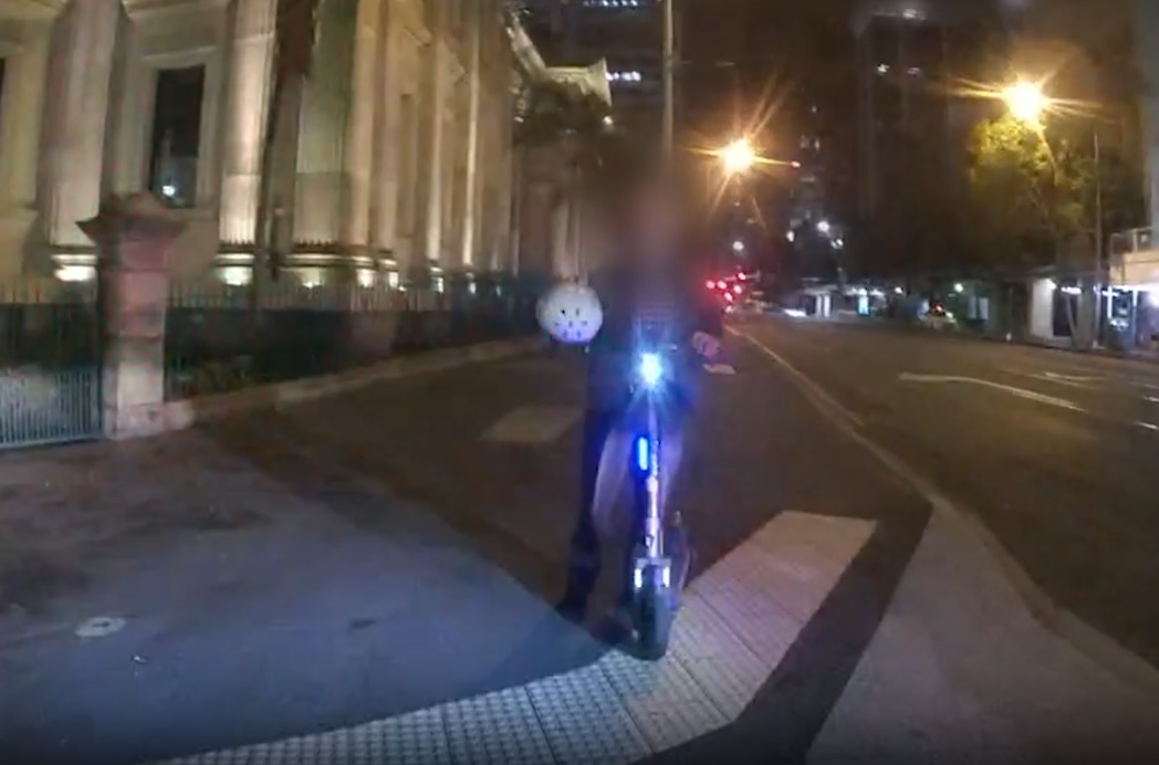 a man riding an e-scooter in brisbane with no helmet on