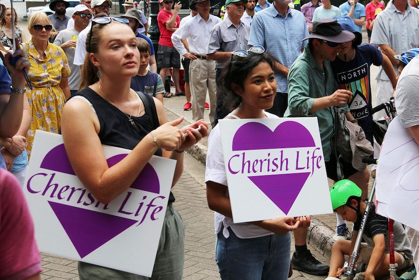Two women hold up 'Cherish Life' signs at an anti-abortion rally on March 18, 2018, in Brisbane's CBD.