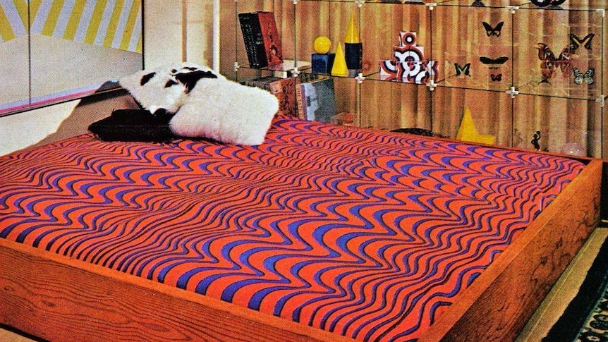 An orange and purple waterbed patterned with curves.