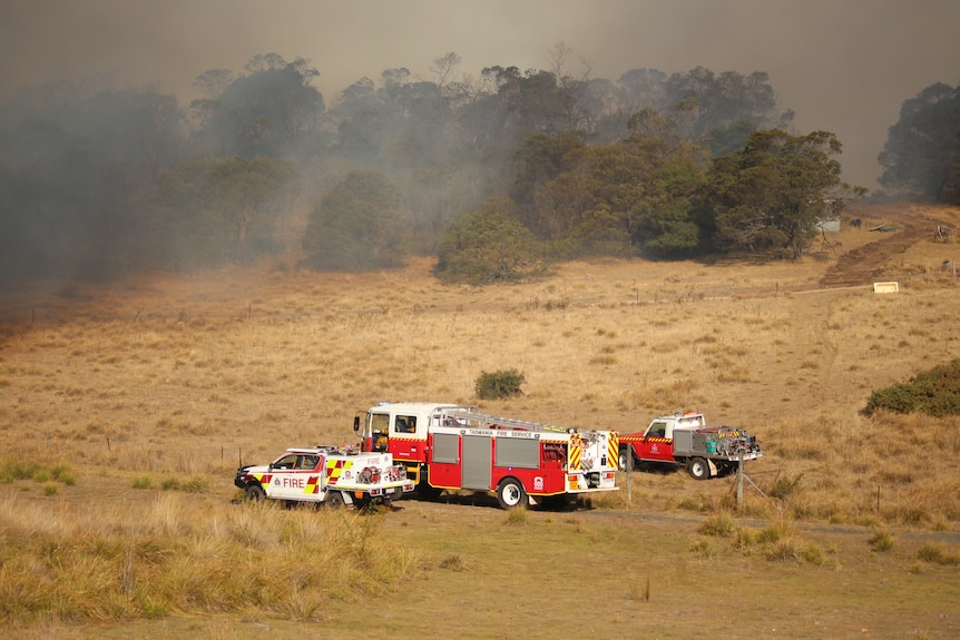 Firefighting trucks in a field near the Ravenswood bushfire.