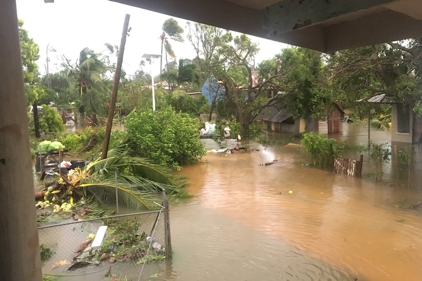 Floodwaters and debris surrounds houses.