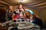Kyran with his family in a tent.