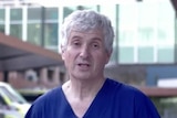 A man in hospital scrubs speaks