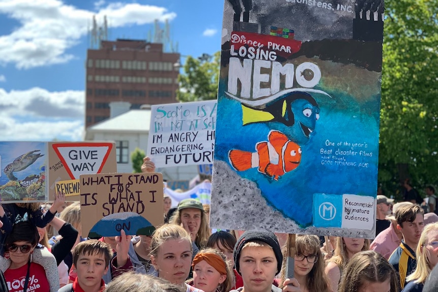 A student holds a "Losing Nemo" sign at a climate change rally in Hobart