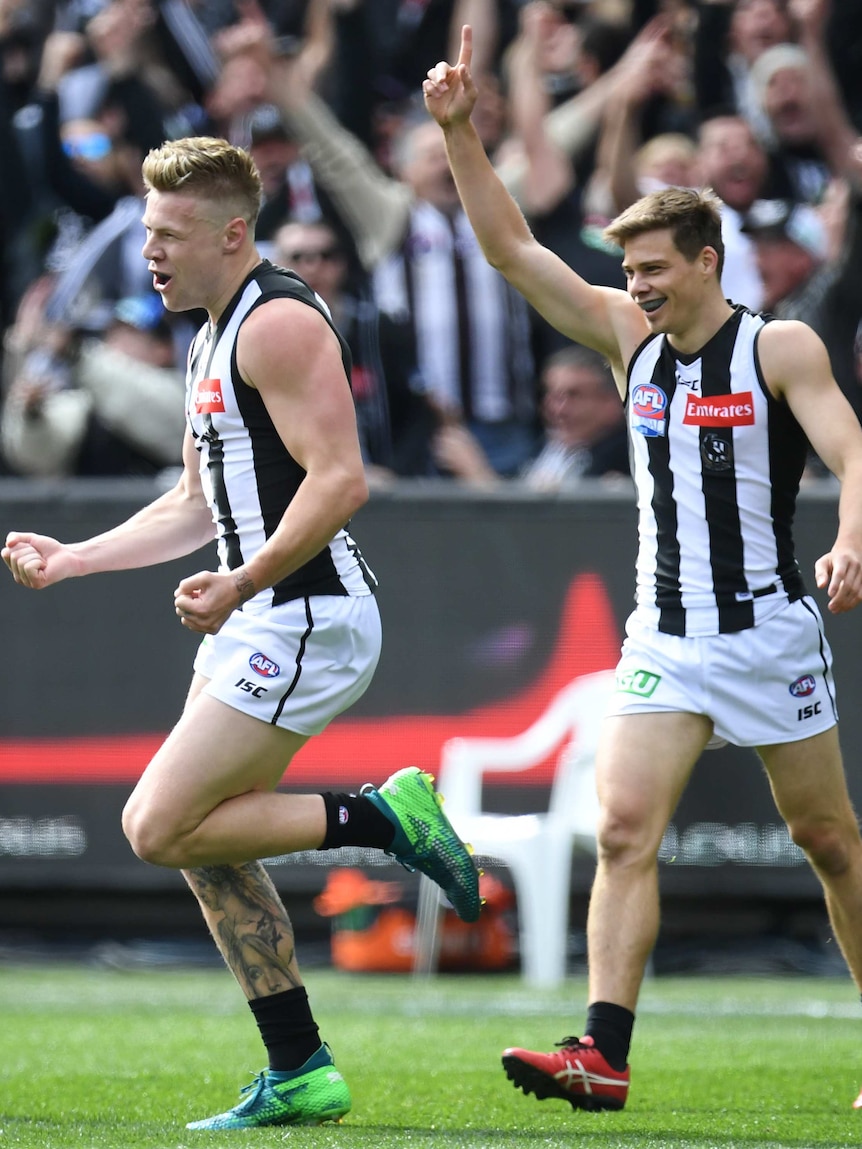 Jordan de Goey and Josh Thomas celebrate a goal for Collingwood in the AFL grand final.