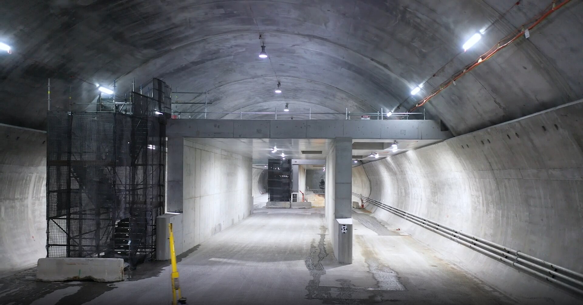 concrete tunnel lit across the ceiling