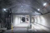 concrete tunnel lit across the ceiling